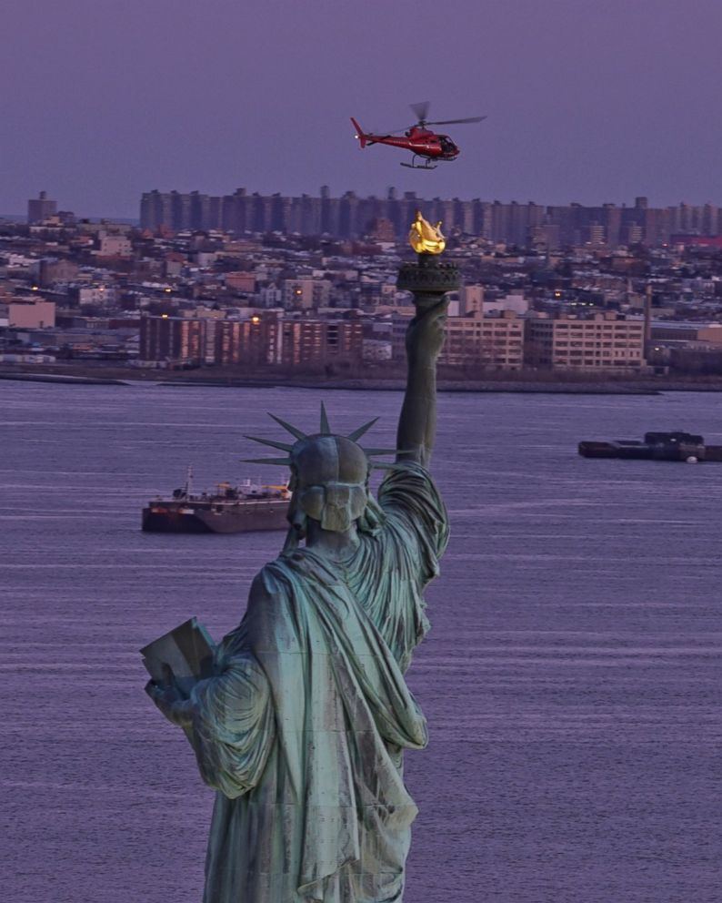 PHOTO: A chartered helicopter that later crashed into New York's East River flies past the Statue of Liberty in New York, March 11, 2018.