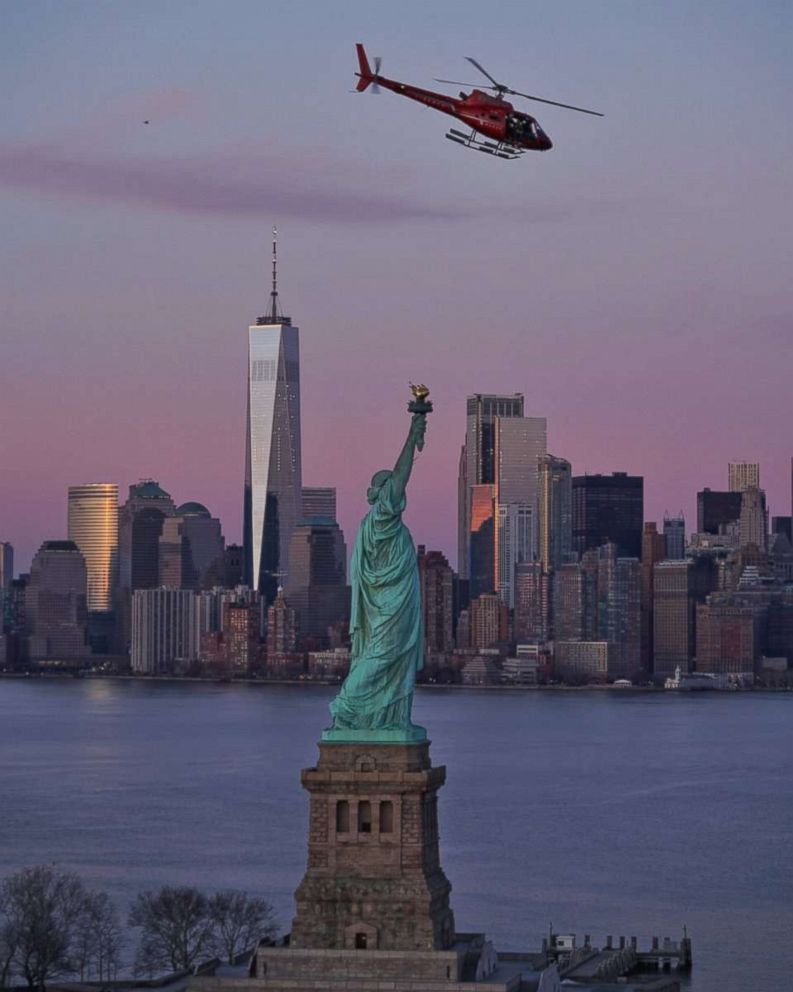 PHOTO: A chartered helicopter that later crashed into New York's East River flies past the Statue of Liberty in New York, March 11, 2018.