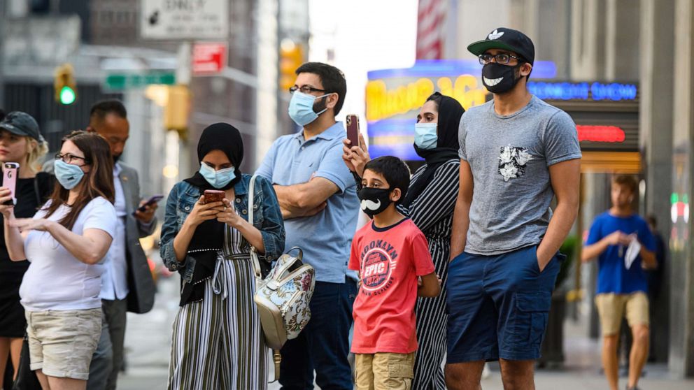 PHOTO: People wear protective face masks outside Radio City Music Hall as New York City moves into Phase 3 of re-opening following restrictions imposed to curb the coronavirus pandemic on July 12, 2020.