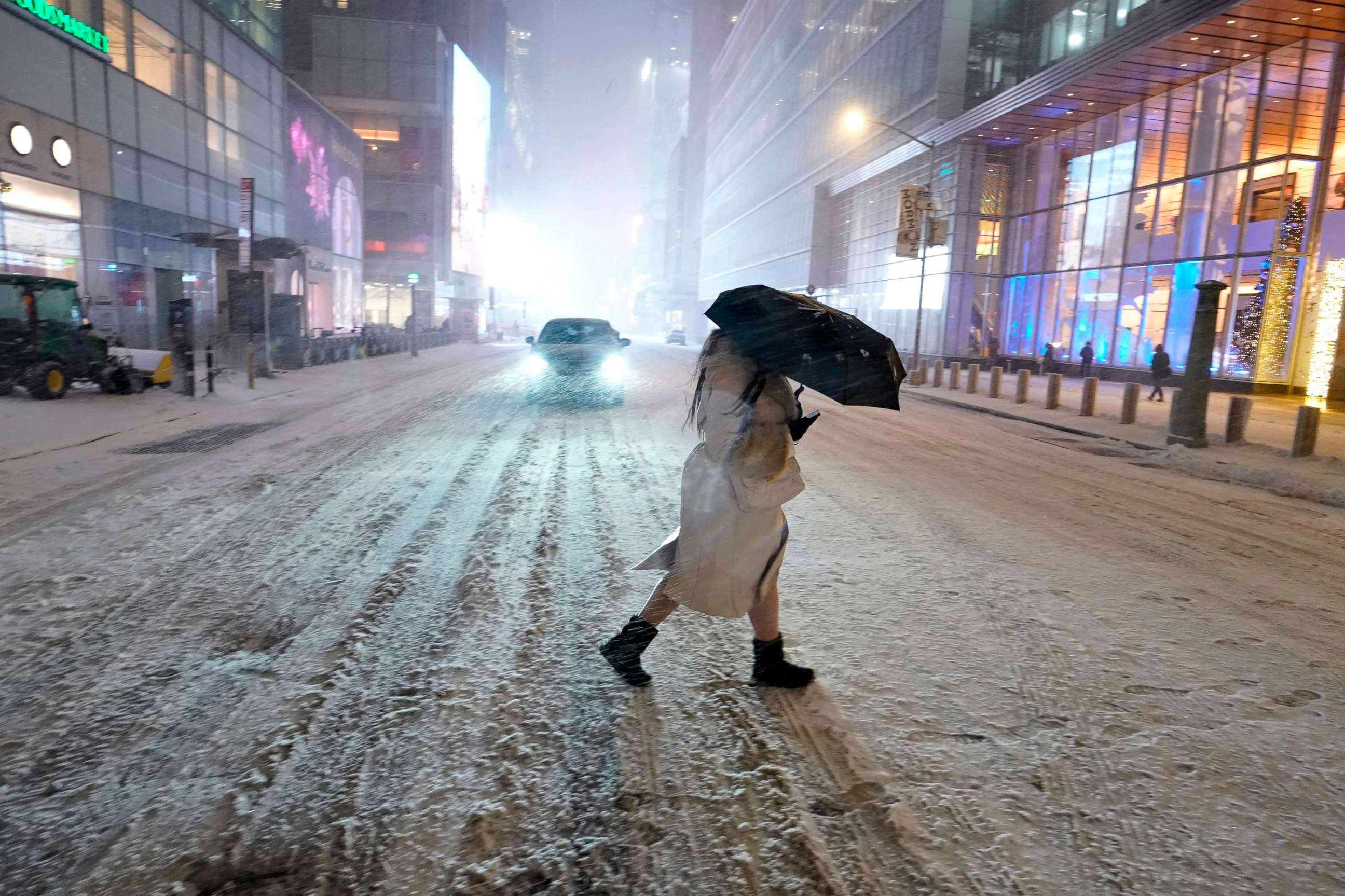 PHOTO: TOPSHOT - A person holds an umbrella as she walks under the snow in Times Square in New York City, Dec. 16, 2020.