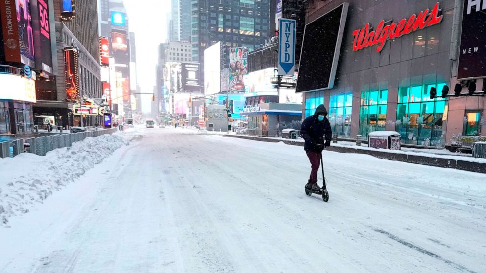 PHOTO: TOPSHOT - A man travels on a scooter in Times Square on Dec. 17, 2020 in New York, the morning after a powerful winter storm hit the U.S.