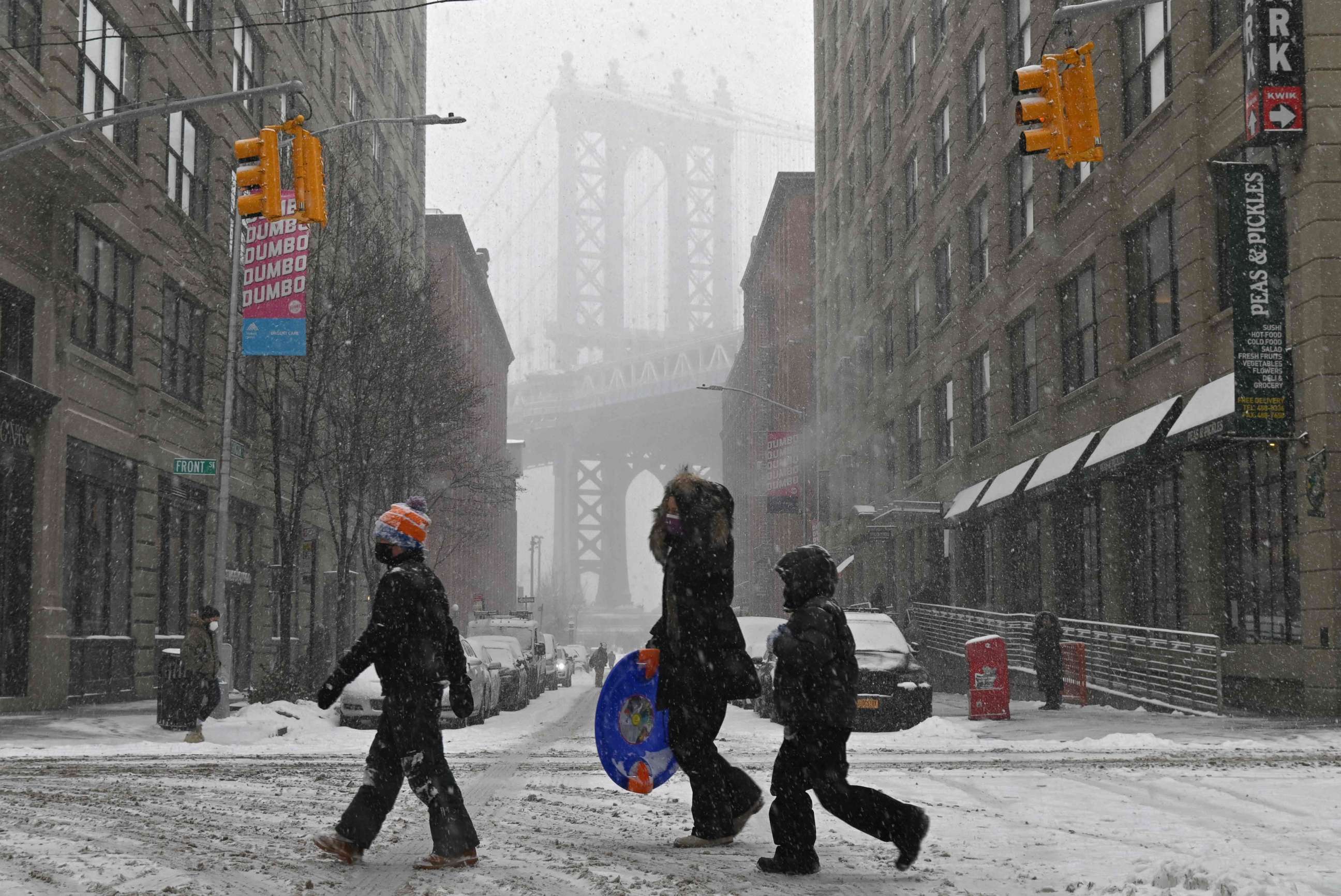 PHOTO: TOPSHOT - People walk through the snow in New York, on Feb. 18, 2021, after a snowstorm.