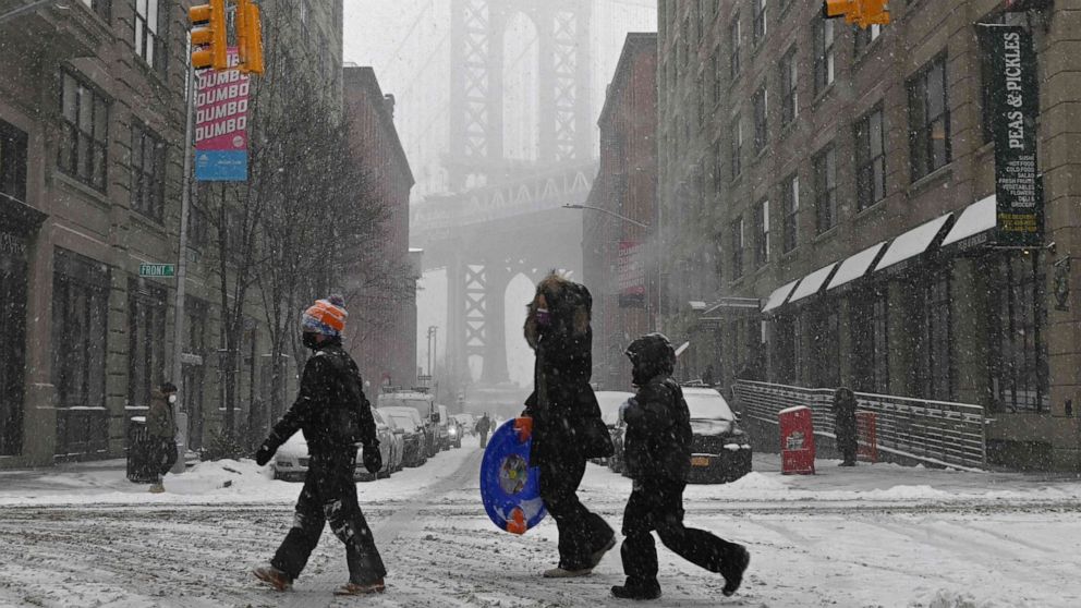 PHOTO: TOPSHOT - People walk through the snow in New York, on Feb. 18, 2021, after a snowstorm.