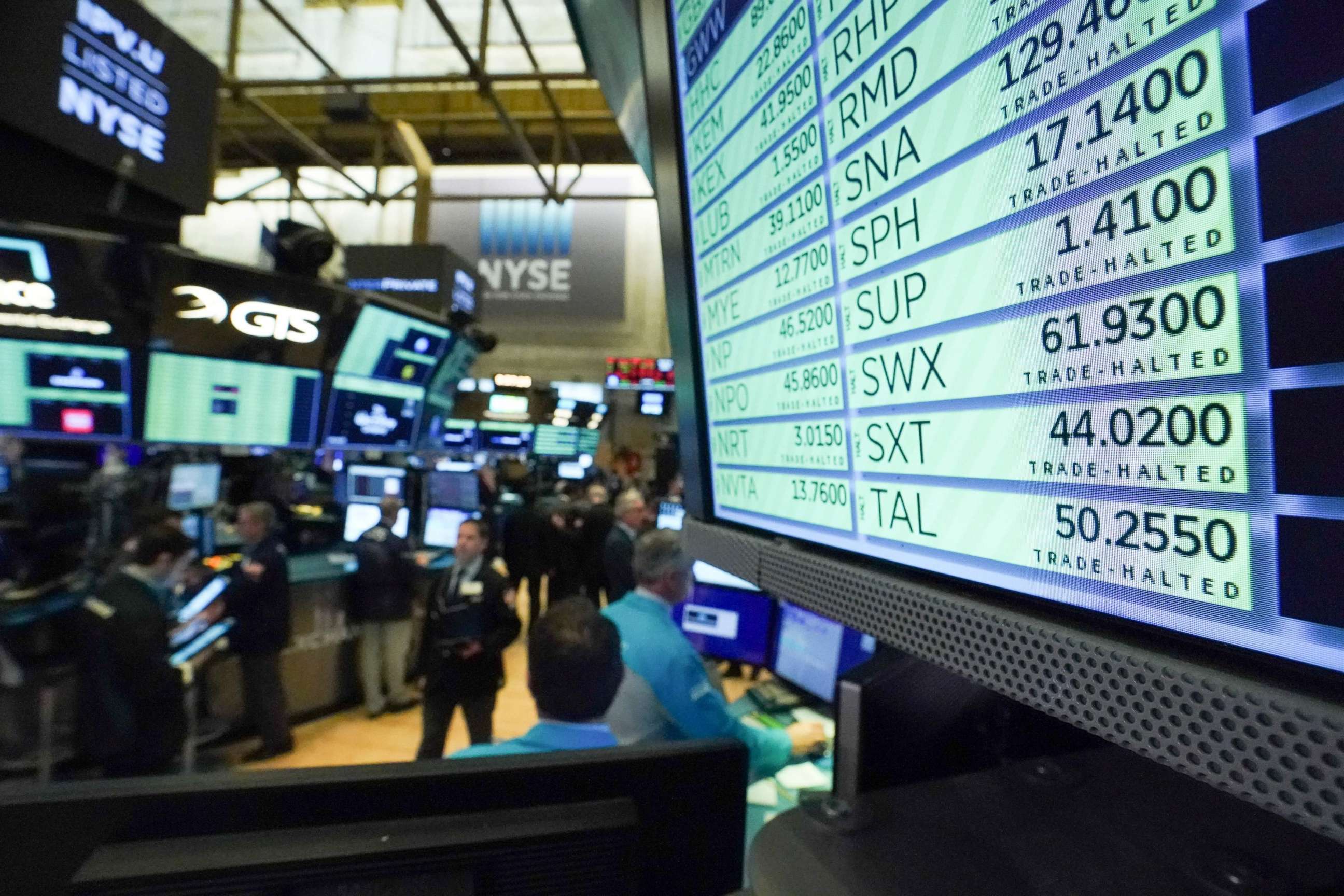 PHOTO: Trading is halted for 15 minutes as traders work on the floor at the opening bell of the Dow Industrial Average at the New York Stock Exchange on March 12, 2020, in New York.