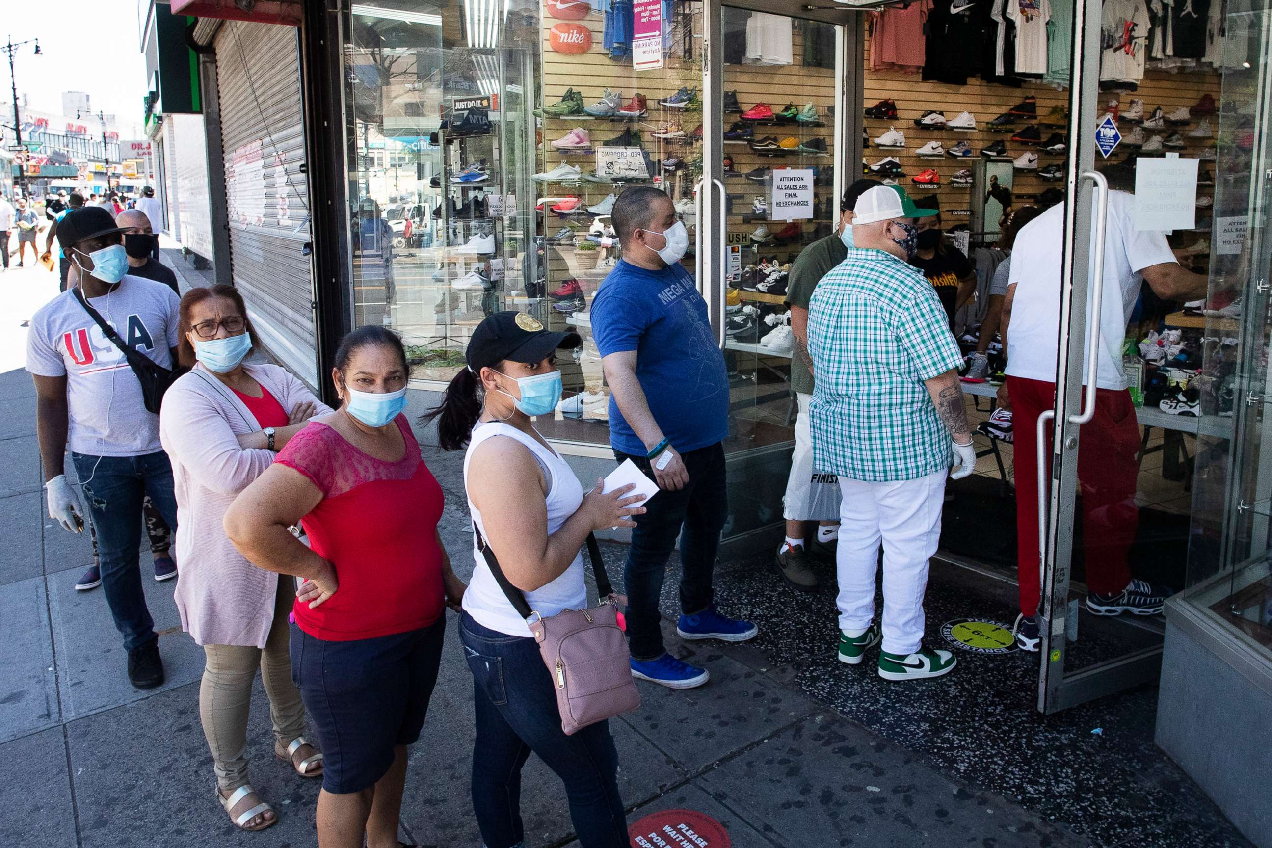PHOTO: People with their face masks stand in line to enter a Sneaker Box after it reopens, June 8, 2020, in the Bronx borough of New York.