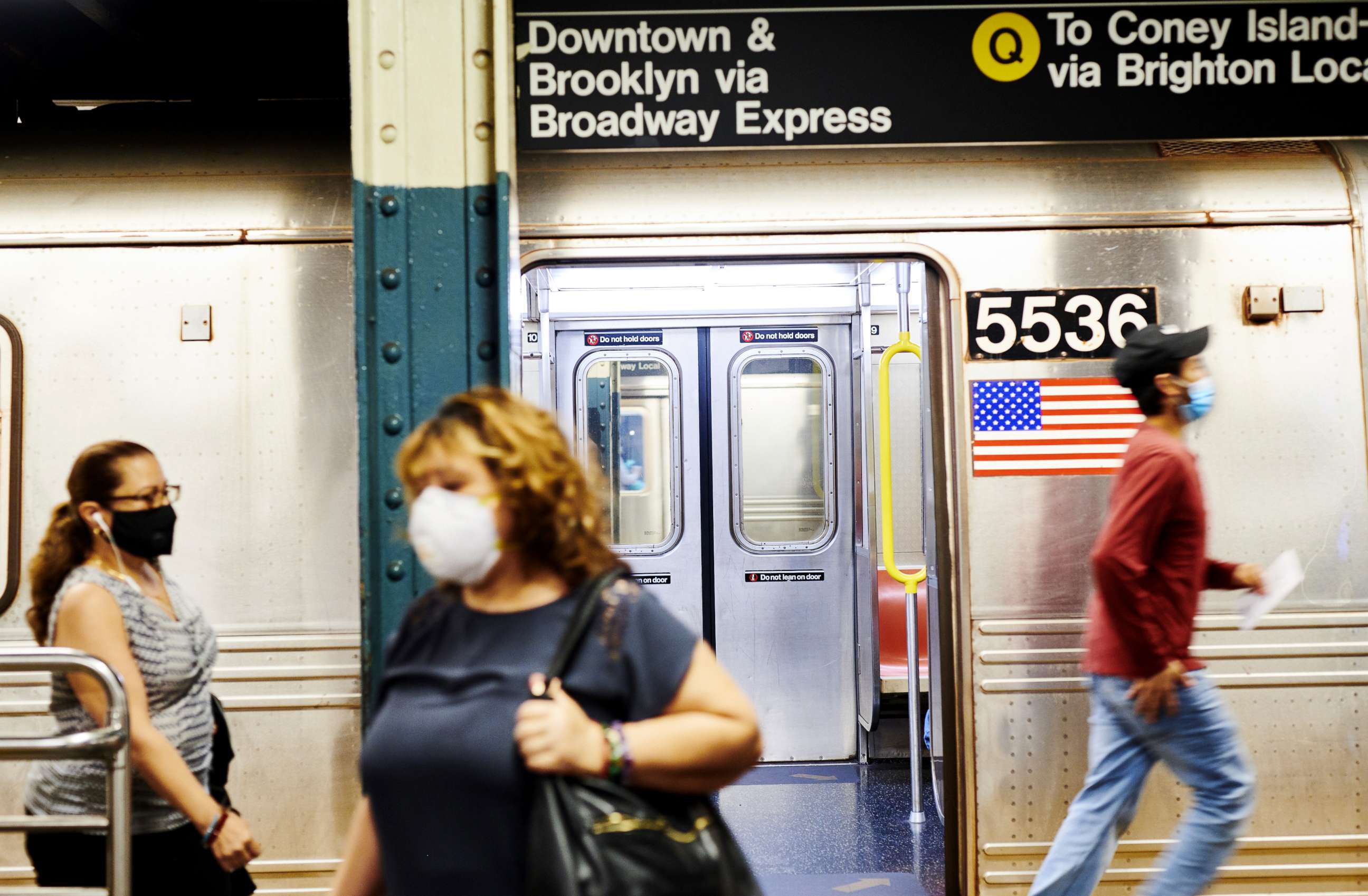 PHOTO: Commuters wearing protective masks exit from a subway car at the 42nd street station in New York, on June 9, 2020.