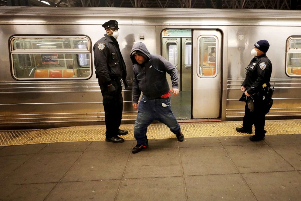 PHOTO: A man runs past Police officers as they patrol the New York City subway system, May 7, 2020.