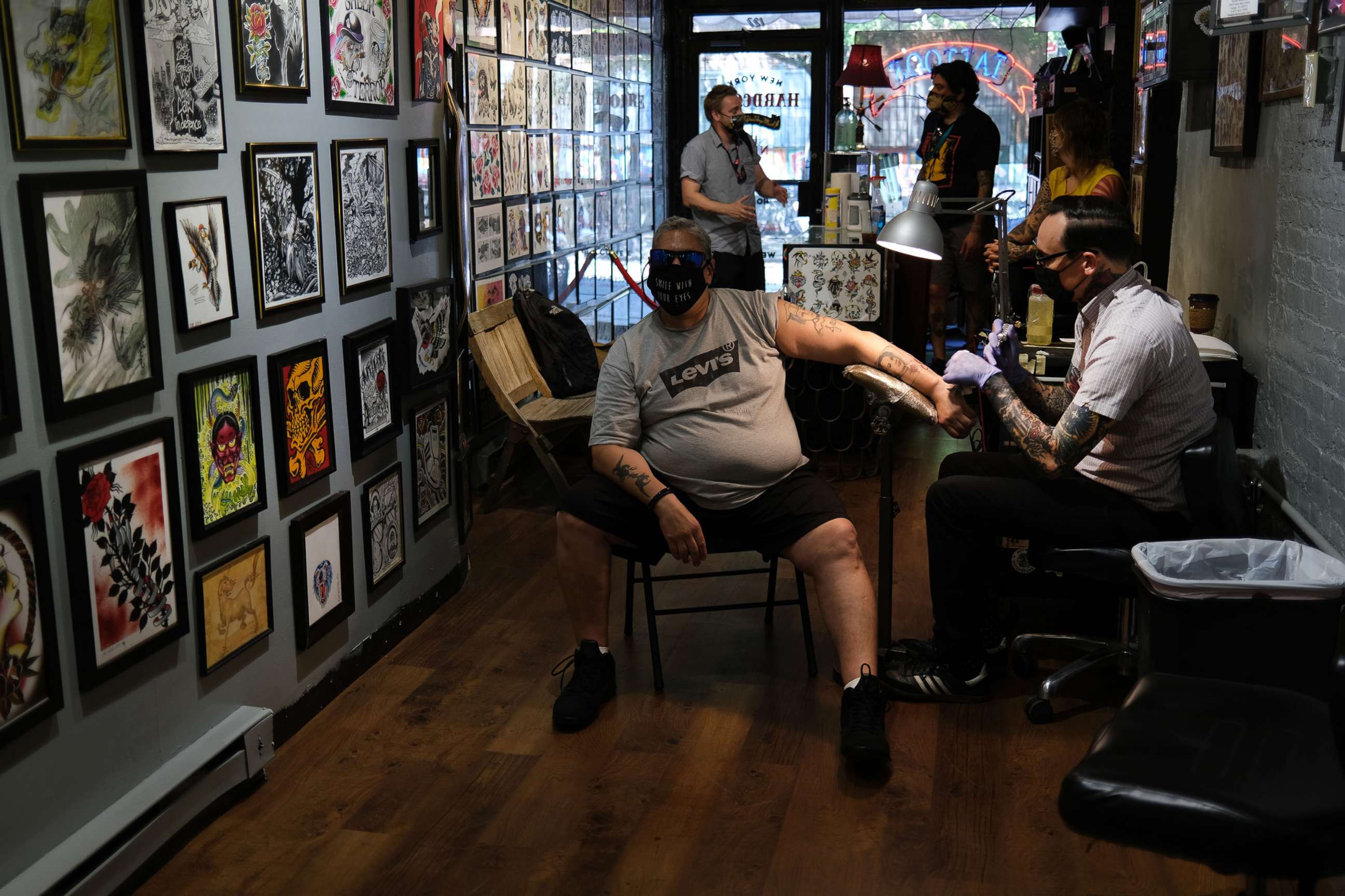 PHOTO: Artist Jeremy Miller gives Jay Rivera a tattoo at New York Hardcore Tattoos on the first day of re-opening as New York City officially begins Phase Three of opening on July 06, 2020, in New York.