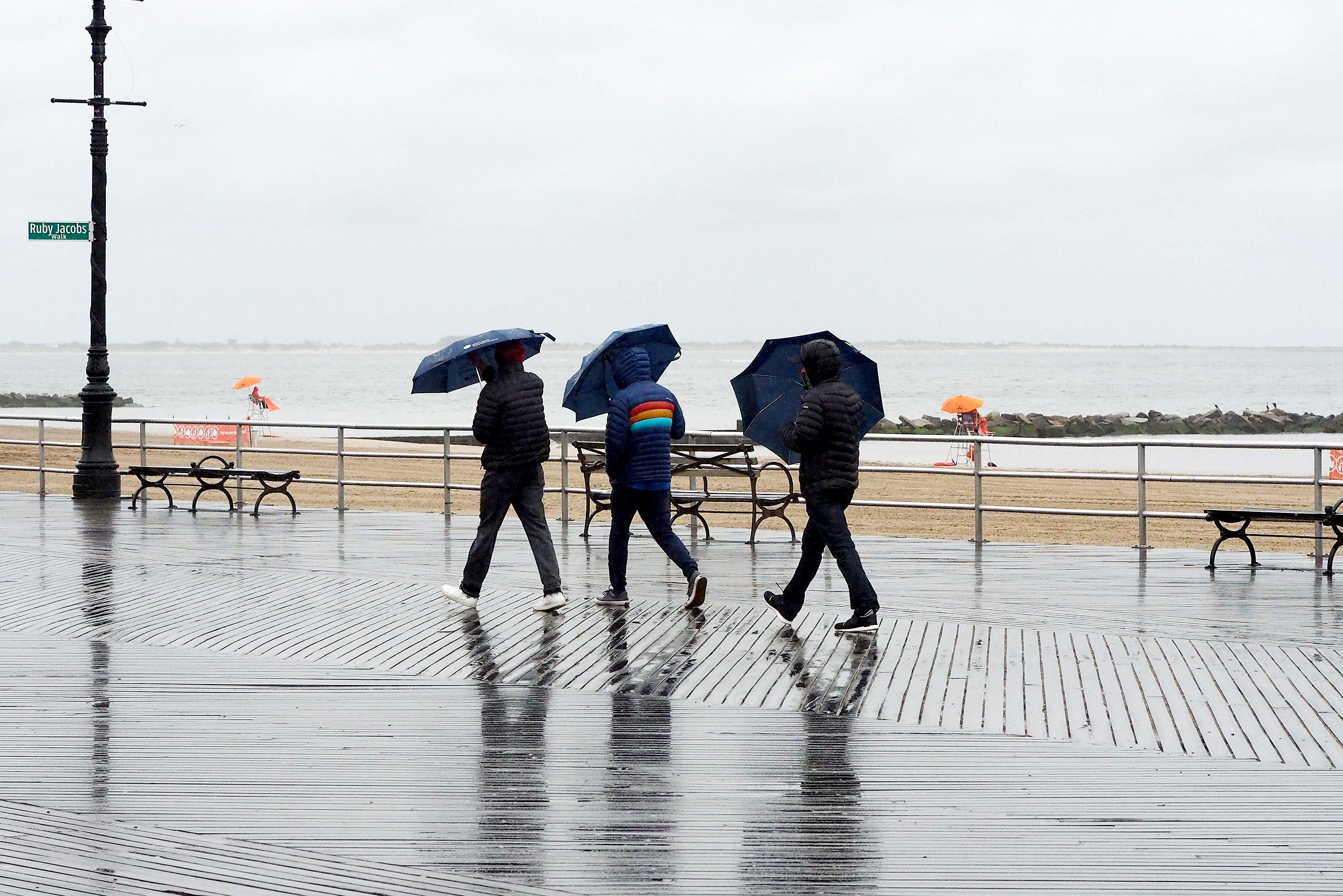 PHOTO: People walk the Coney Island boardwalk in New York City, May 29, 2021, as rain and cold weather dampen the official opening day of beaches in New York State during Memorial Day weekend.