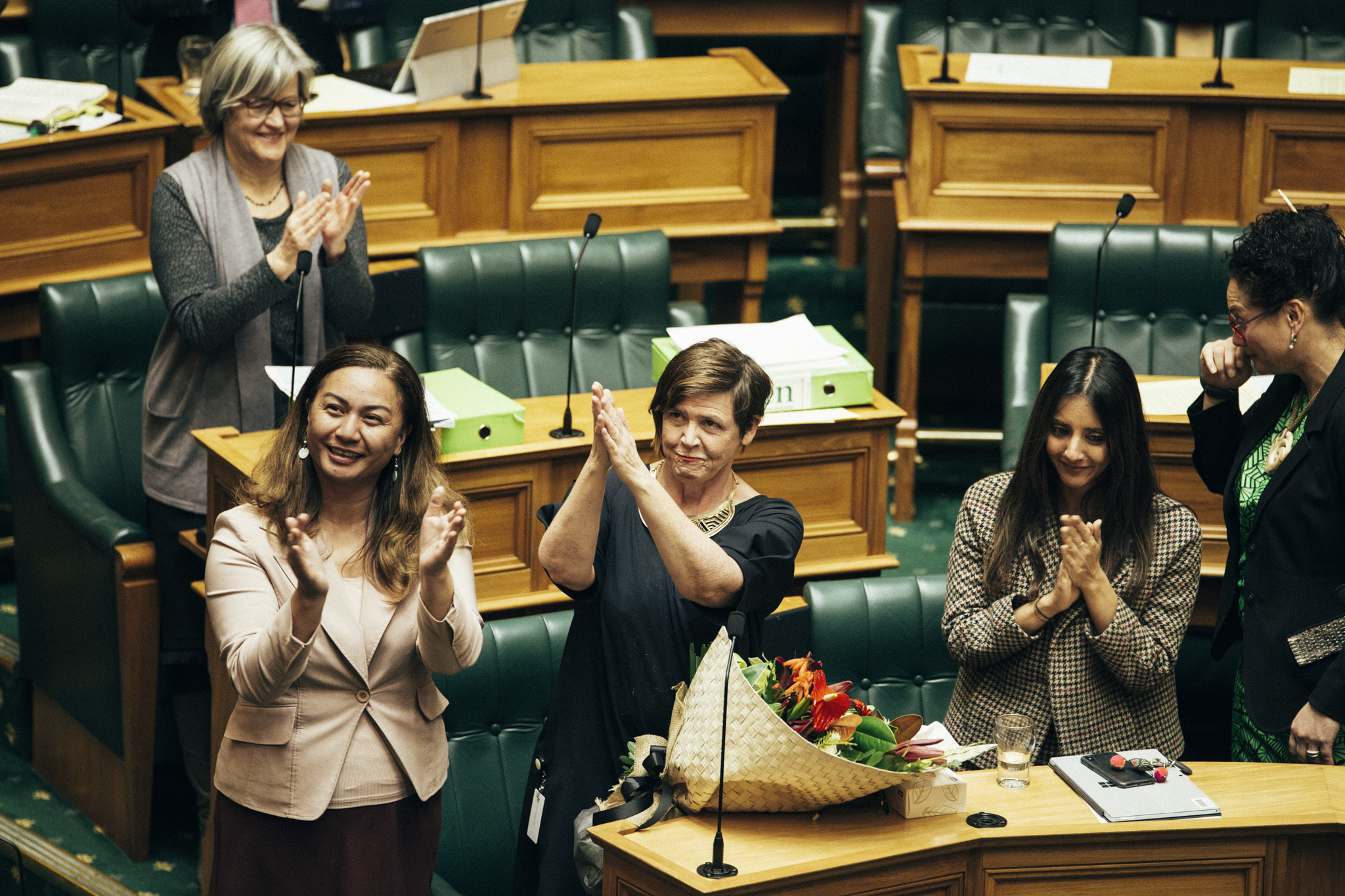 PHOTO: Marama Davidson, Jan Logie, and Golriz Ghahraman, members of the New Zealand House of Representatives, applaud after the passage of a bill to grant victims of domestic violence paid leave from work, in Wellington, New Zealand, July 25, 2018.