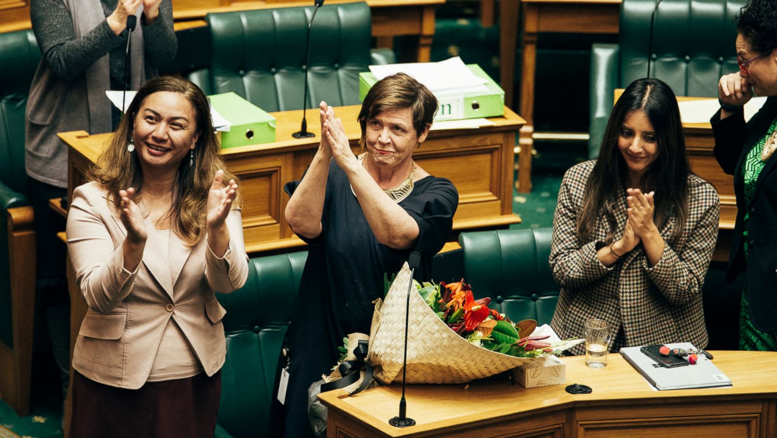 PHOTO: Marama Davidson, Jan Logie, and Golriz Ghahraman, members of the New Zealand House of Representatives, applaud after the passage of a bill to grant victims of domestic violence paid leave from work, in Wellington, New Zealand, July 25, 2018.