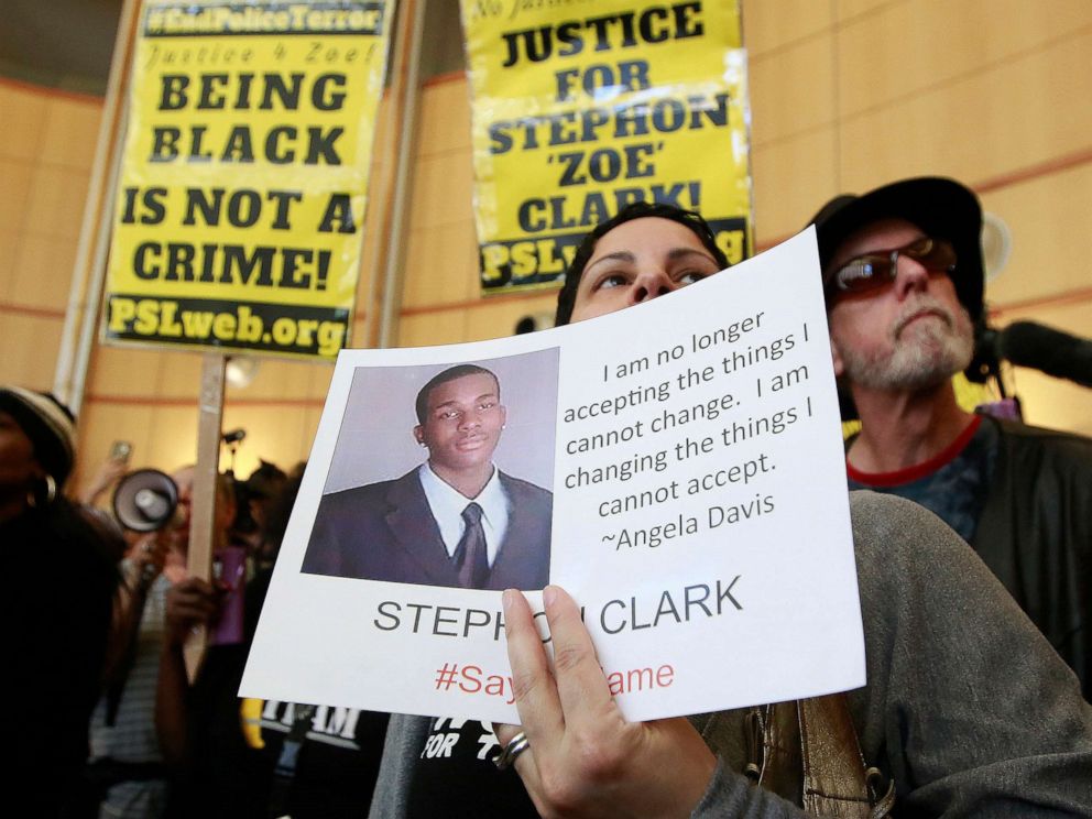 PHOTO: In this March 22, 2018, file photo, Anita Ross holds a photo of 22-year-old Stephon Clark, who was fatally shot by Sacramento police, as she and other protesters block the entrance to Sacramento City Hall in Sacramento, Calif. 