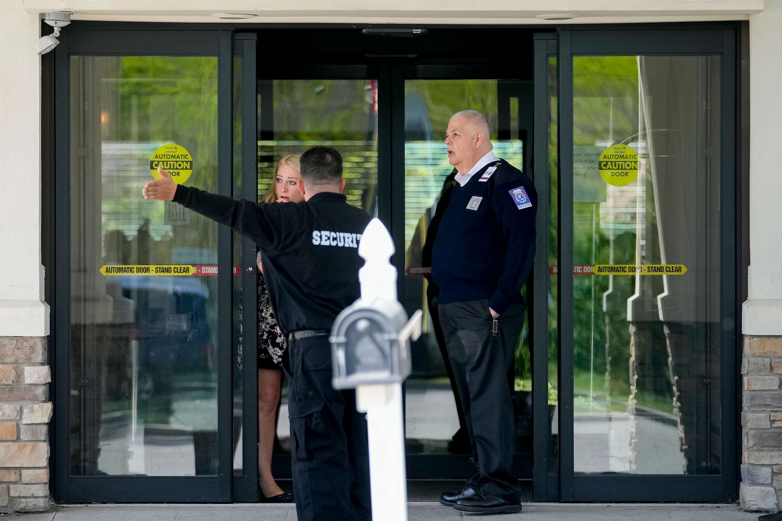 PHOTO: Security and staff personnel mill around The Crossroads Hotel where two busloads of migrants arrived hours earlier, Thursday, May 11, 2023, in Newburgh, N.Y.