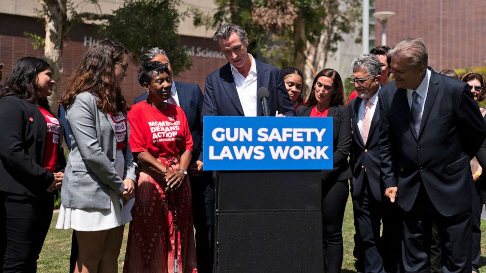 PHOTO: State officials and gun violence survivors watch as California Gov. Gavin Newsom signs a gun control law during a news conference held on the campus of Santa Monica College in Santa Monica, Calif., July 22, 2022.