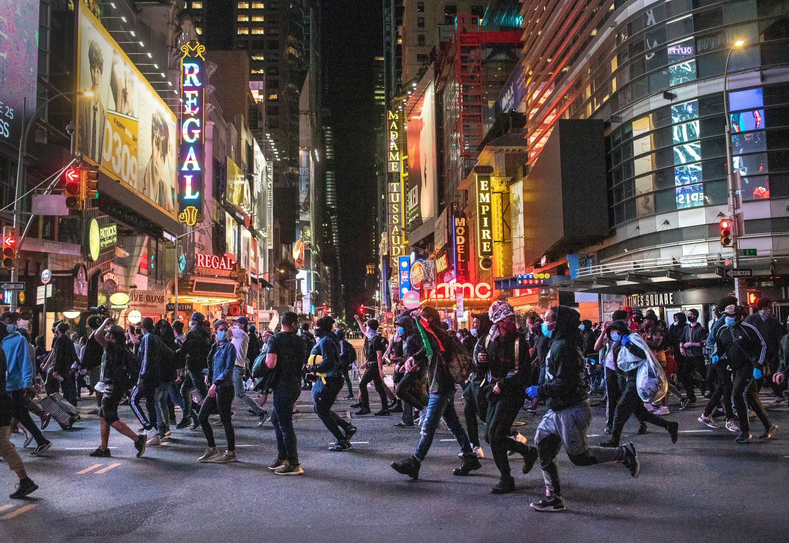 PHOTO: Protesters rush past Times Square after an 11pm curfew during a night of marches and vandalism over the death of George Floyd on June 1, 2020 in New York City.