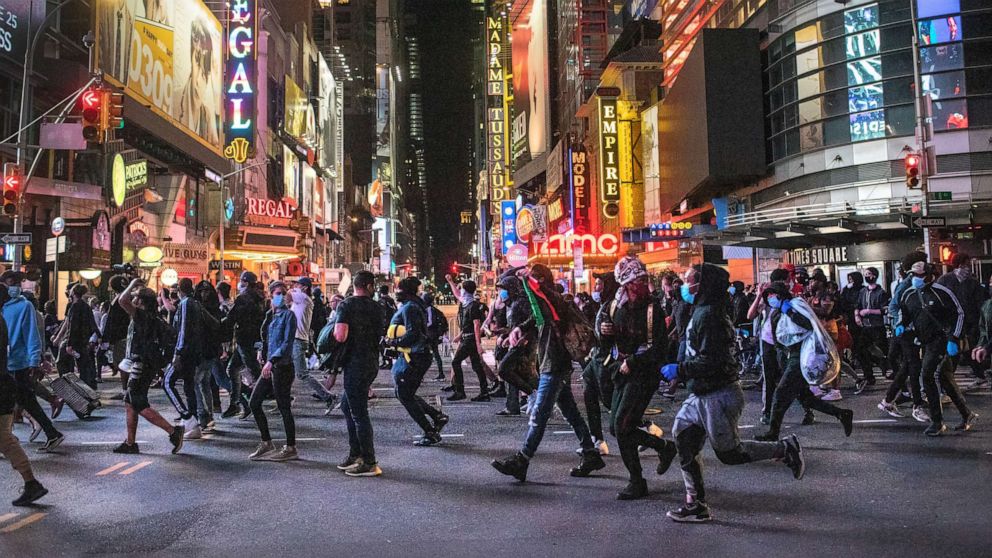 PHOTO: Protesters rush past Times Square after an 11pm curfew during a night of marches and vandalism over the death of George Floyd on June 1, 2020 in New York City.