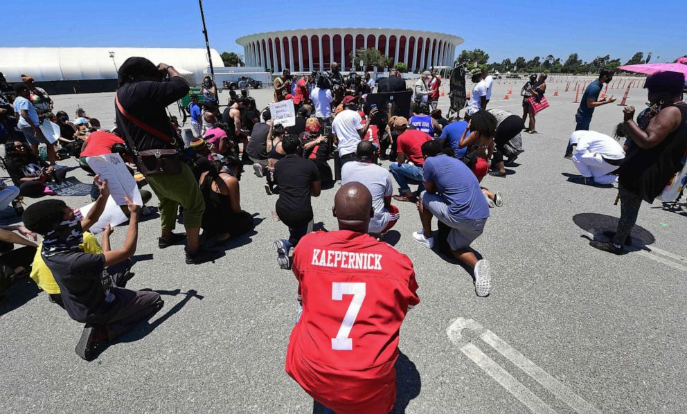 PHOTO: A protester wearing a Colin Kaepernick 49ers jersey joins others in taking a knee, led by Former NFL wide receiver Terrell Owens in support of former NFL quarterback Colin Kaepernick, June 11, 2020 in Inglewood, Calif.