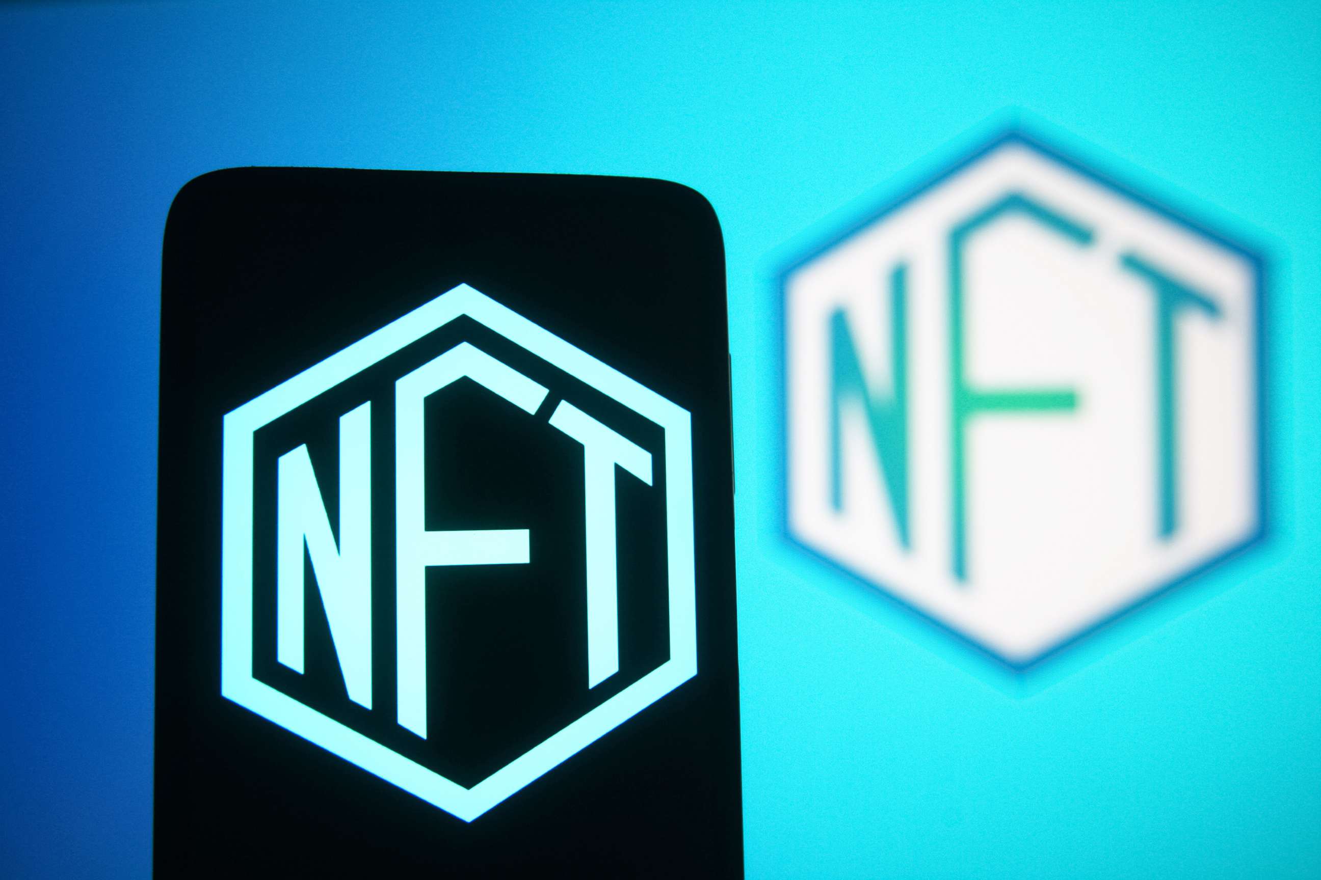 PHOTO: In this photo illustration, a NFT (Non-fungible token) sign is seen on a smartphone and a computer screen. 