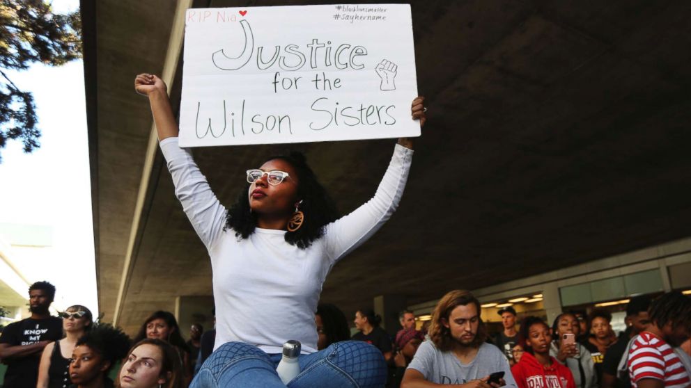 PHOTO: Jasmine Malone, 23, holds a sign at a vigil held for 18-year-old Nia Wilson, who was stabbed to death the previous night on July 23, 2018, at the MacArthur BART station in Oakland, Calif.