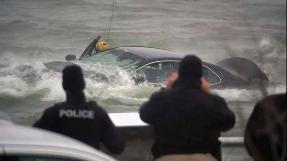 PHOTO: U.S. Coast Guard personnel respond to a car in the river near Niagara Falls, as others watch from the shore, Dec. 8, 2021. 