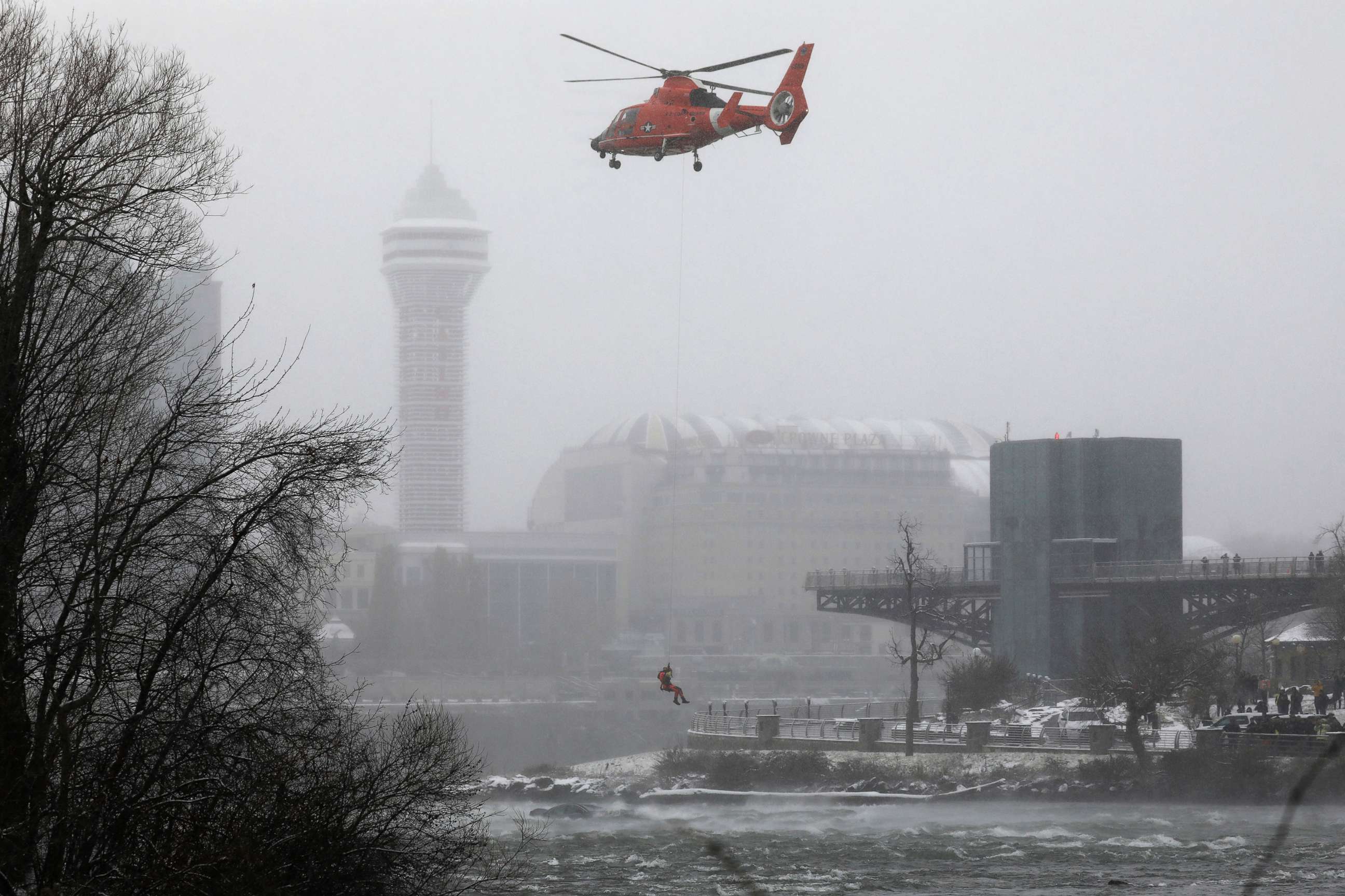 PHOTO: A U.S. Coast Guard rescue diver is lowered toward the vehicle lodged in the water at the brink of Niagara Falls, Dec. 8, 2021.