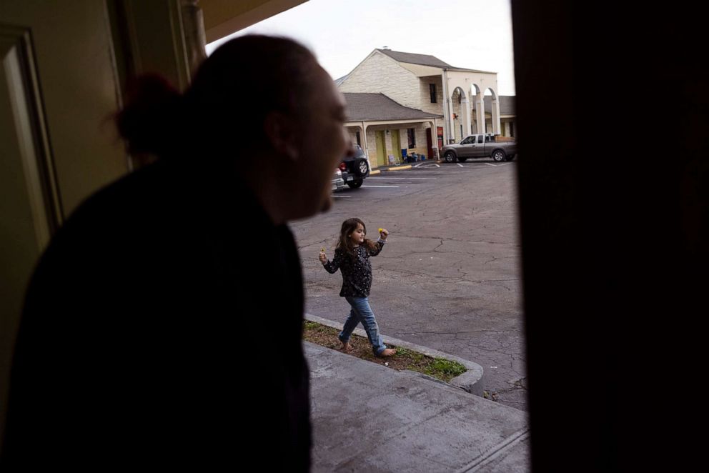PHOTO: NyAnna plays outside while her mother, Nicki Schools watches from the doorway of their motel room in Richmond, Va., Jan. 6, 2022. Nicki said she wants to get out of the motel for NyAnna.