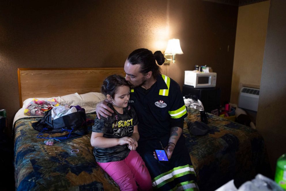 PHOTO: Brian House kisses his daughter NyAnna after coming home from work, Jan. 10, 2022, in Richmond, Va. After being out of work for a while during the pandemic, House was very excited to land a job changing tires on 18-wheelers.