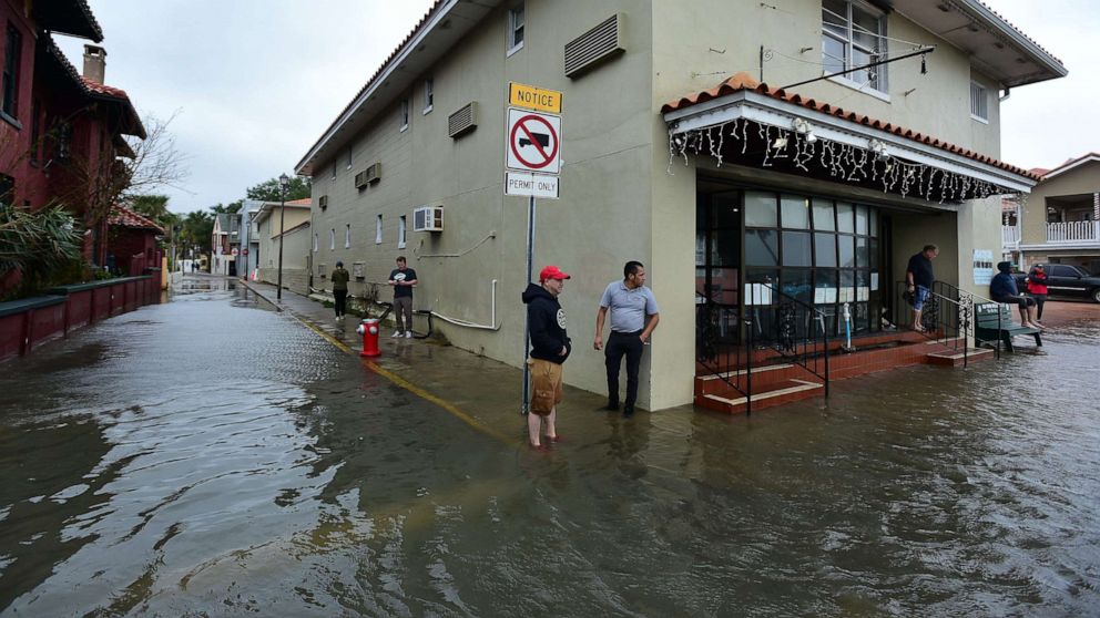 PHOTO: Spectators look at the flooding along Avenida Menendez in the Saint Augustine, Fla. historic district after storm driven high tides flooded low lying areas of the city.