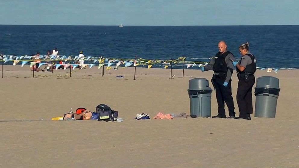 PHOTO: Authorities stand near some belongings left on the beach after a stabbing at Point Pleasant Beach in New Jersey on Sept. 7, 2020.