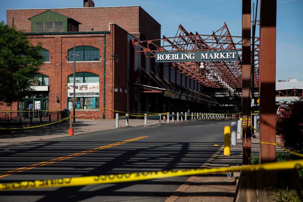 PHOTO: Police officers inspect the crime scene at the Roebling Market, June 17, 2018, the morning after a shooting at an all-night art festival injured 20 people and left one person dead in Trenton, New Jersey.