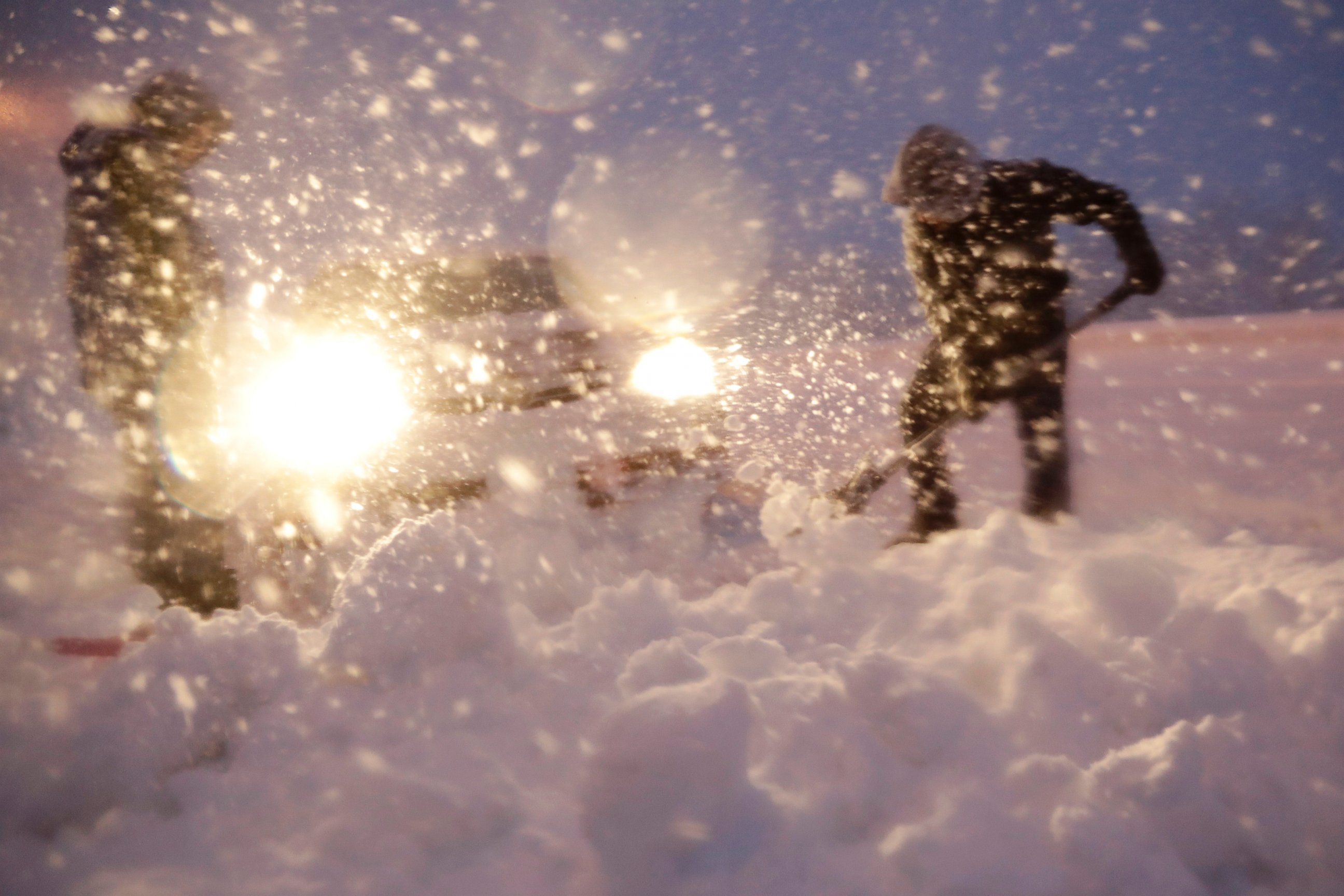 Men shovel snow while trying to free a vehicle stuck on a snowbank along Route 23 during a snowstorm, Wednesday, March 7, 2018, in Wayne, N.J.