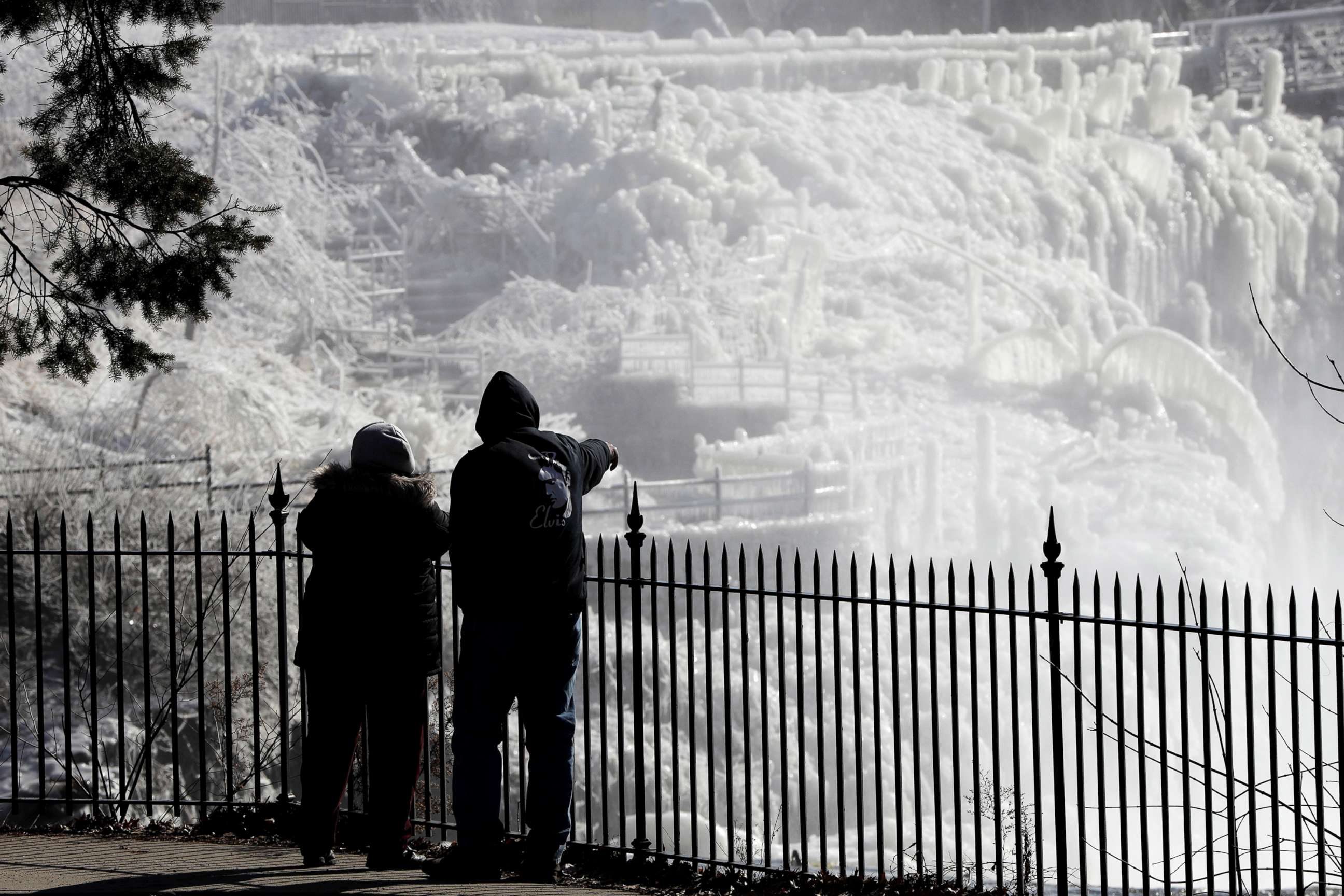 PHOTO: Ice is seen on the side of the Great Falls National Historic Park as a couple takes in the sights during a frigid winter day, Jan. 30, 2019, in Paterson, N.J.