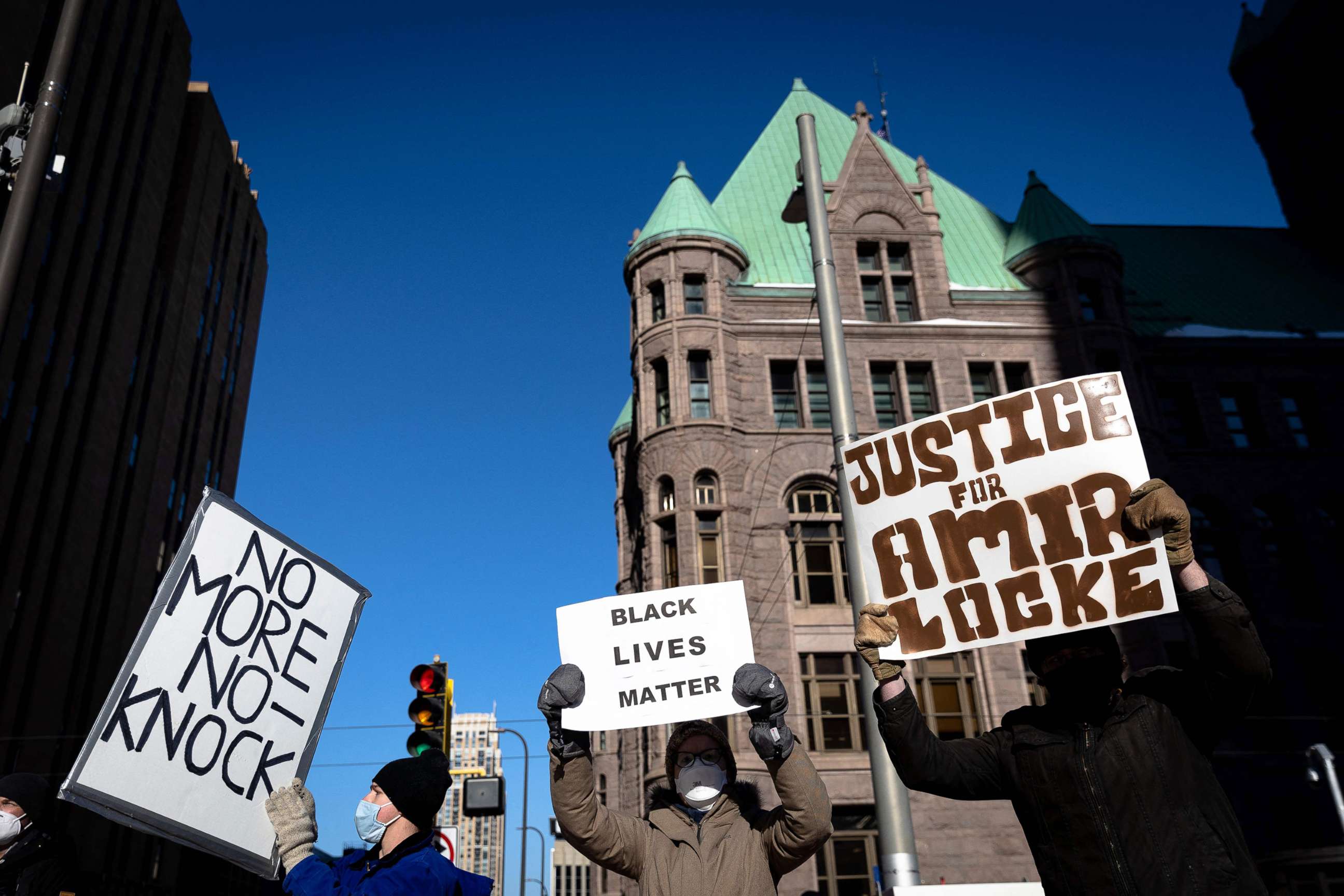 PHOTO: Demonstrators hold signs at a protest over the killing of Amir Locke during a no-knock warrant, outside the Hennepin County Government Center in Minneapolis, Feb. 5, 2022.