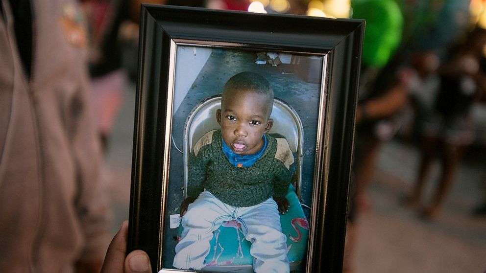 PHOTO: A photo of Noah Sneed is held during a gathering to honor his life with a candlelight memorial in front of the Ceressa's Enrichment and Empowerment Academy in Oakland Park, Fla., July 30, 2019.