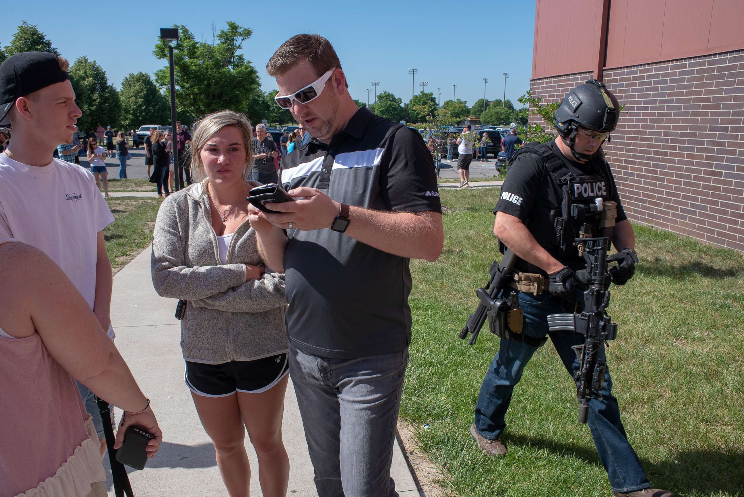 PHOTO: Parents wait while a SWAT officer passes outside Noblesville High School after a shooting at Noblesville West Middle School on May 25, 2018 in Noblesville, Ind.