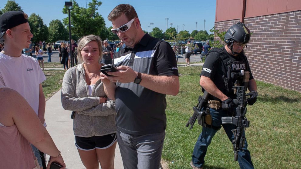 PHOTO: Parents wait while a SWAT officer passes outside Noblesville High School after a shooting at Noblesville West Middle School on May 25, 2018 in Noblesville, Ind.