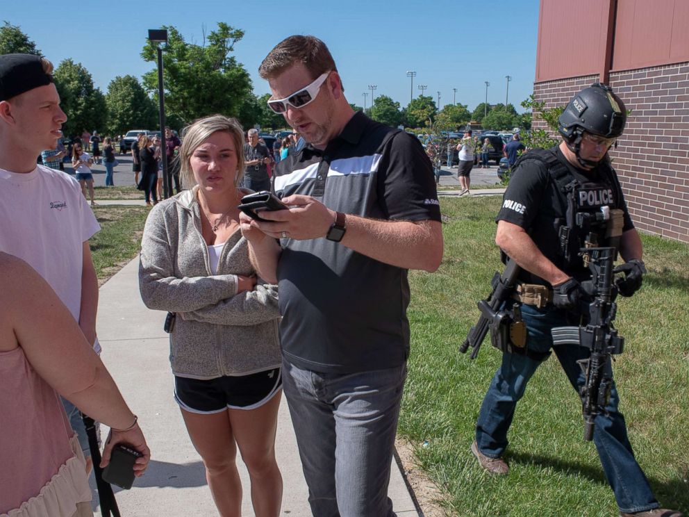 PHOTO: Parents wait while a SWAT officer passes outside Noblesville High School after a shooting at Noblesville West Middle School on May 25, 2018 in Noblesville, Ind.