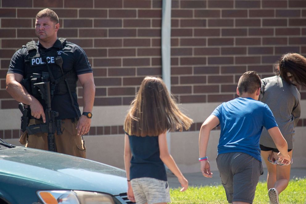 PHOTO: Children file past an armed police officer outside Noblesville High School after a shooting at Noblesville West Middle School on May 25, 2018 in Noblesville, Ind.