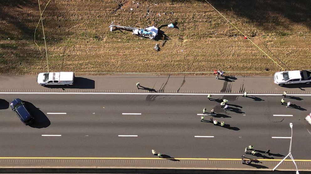 PHOTO: In this image take with a drone, emergency personnel work at the scene of a helicopter crash on the side of Interstate 77 South in Charlotte, N.C., on Nov. 22, 2022. Authorities said two people died.