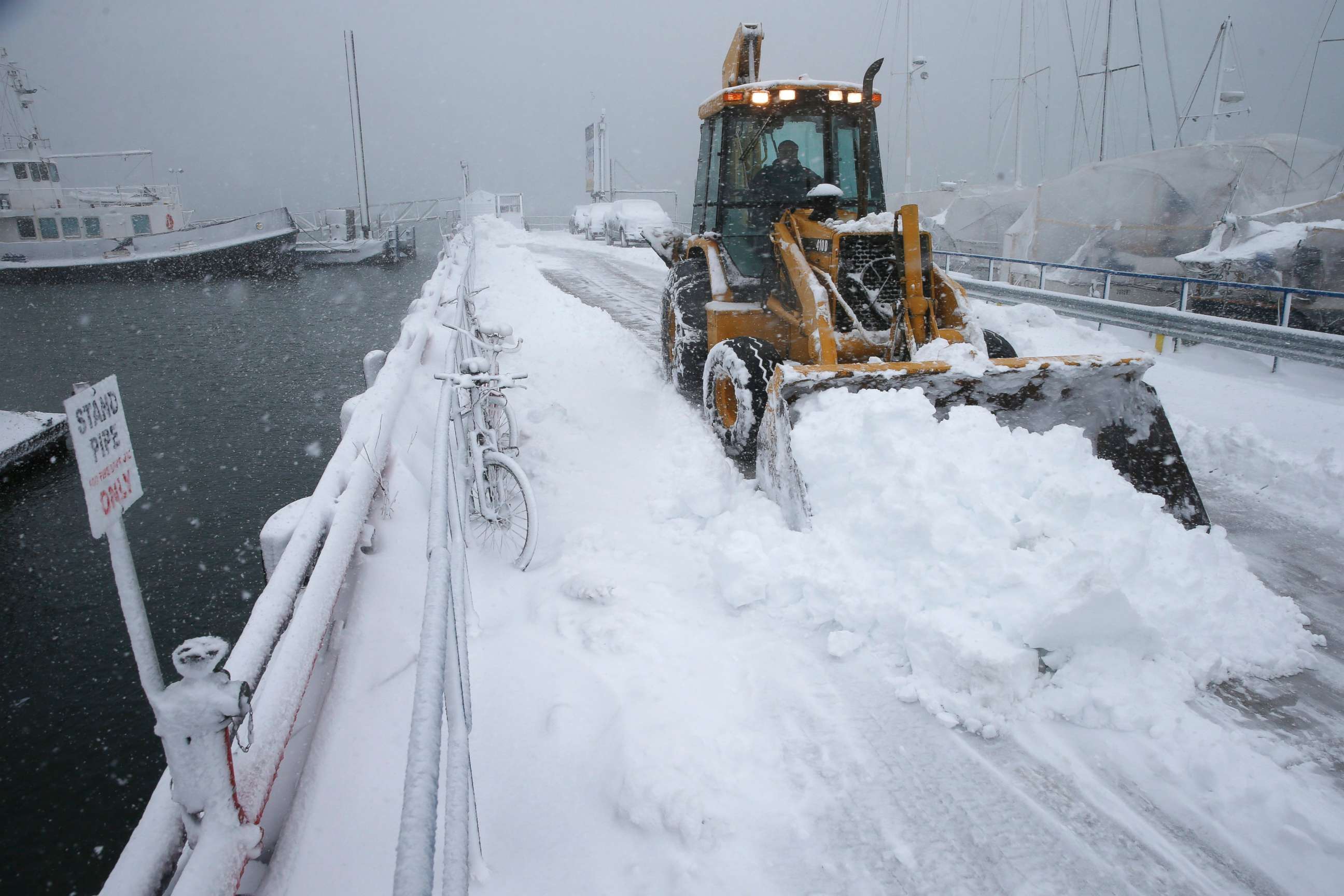 PHOTO: A front end loader clears the pier at the Boston Harbor Shipyard and Marina in Boston, March 13, 2018.