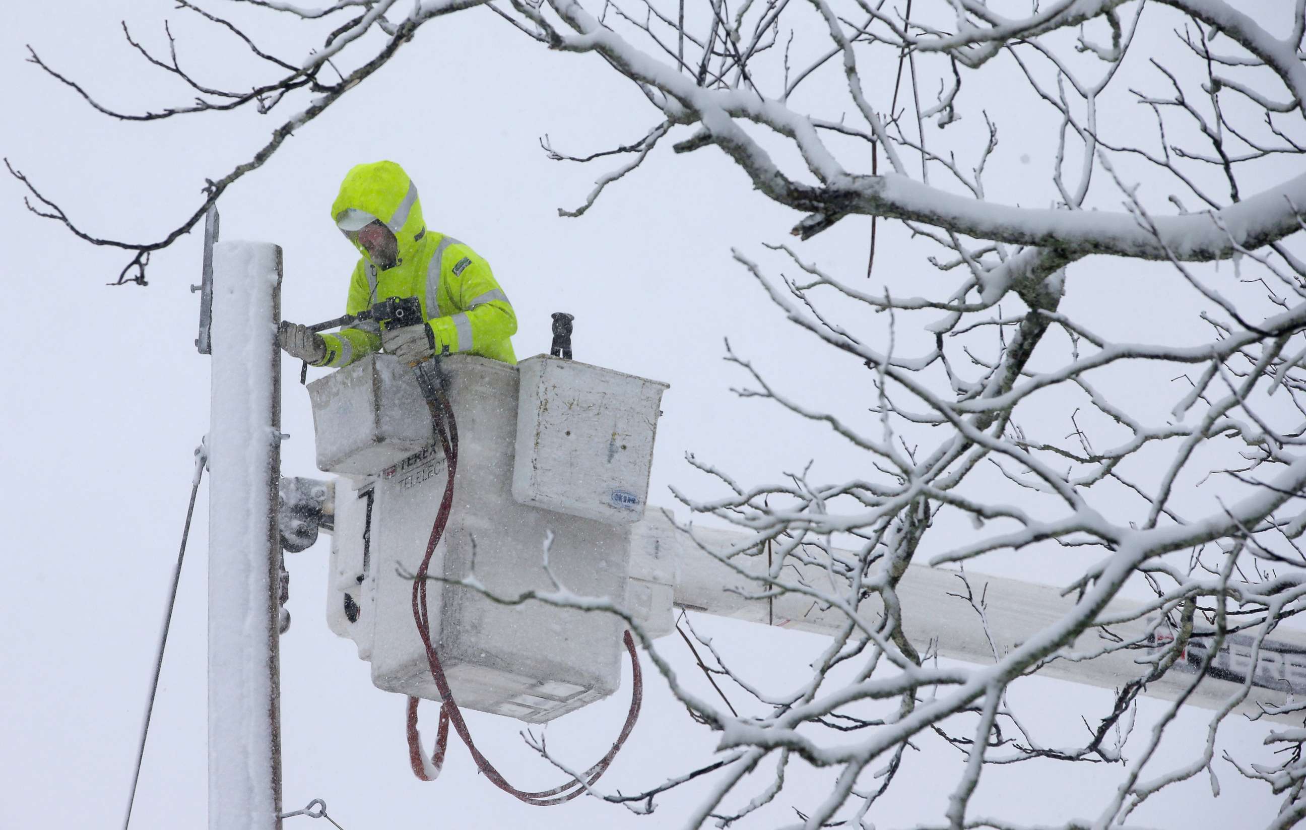 PHOTO: A worker repairs power lines during a winter storm, March 13, 2018, in Norwell, Mass. 