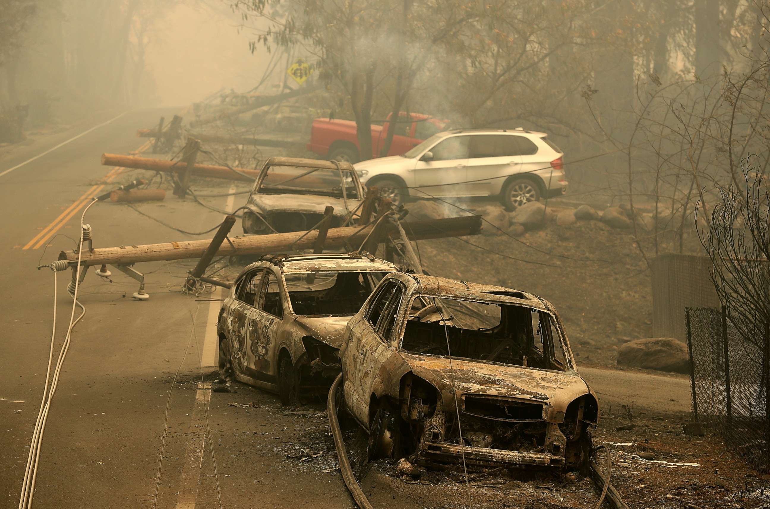 PHOTO: Power lines rest on cars that were burned by the Camp Fire on Nov. 10, 2018 in Paradise, Calif.