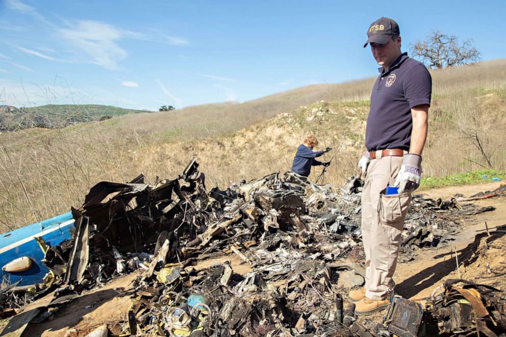 PHOTO: Photo taken Jan. 27, 2020, shows National Transportation Board (NTSB) investigators Adam Huray and Carol Hogan examining the wreckage of the Jan. 26 helicopter crash near Calabasas, Calif., which killed nine people.