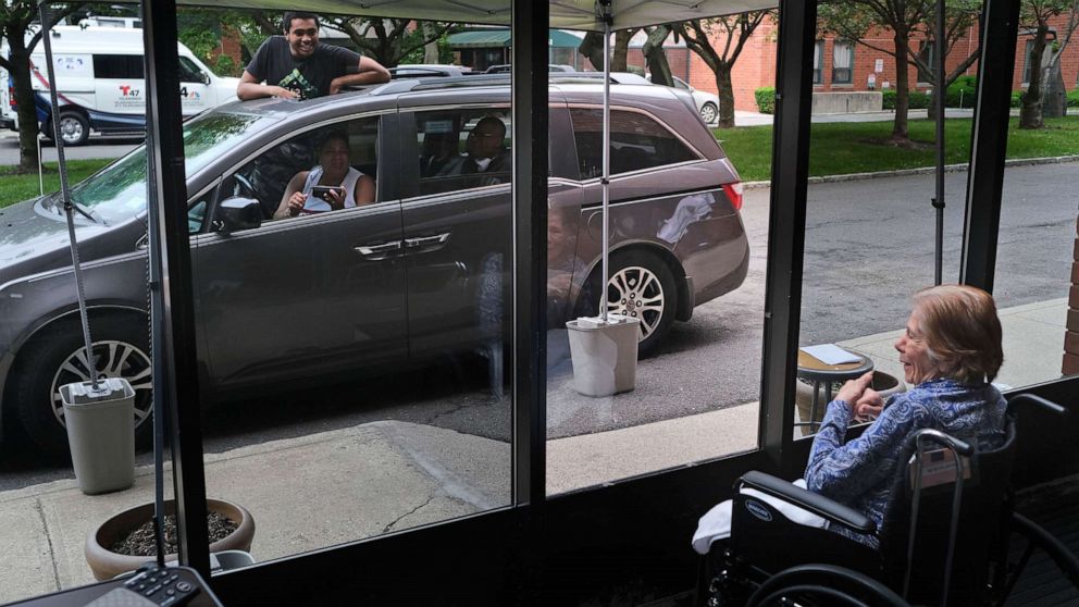 PHOTO: In this June 11, 2020, file photo, Gloria DeSoto, 92, right, visits with her family, in their car, from a window of the Hebrew Home at Riverdale, where she lives, in New York.
