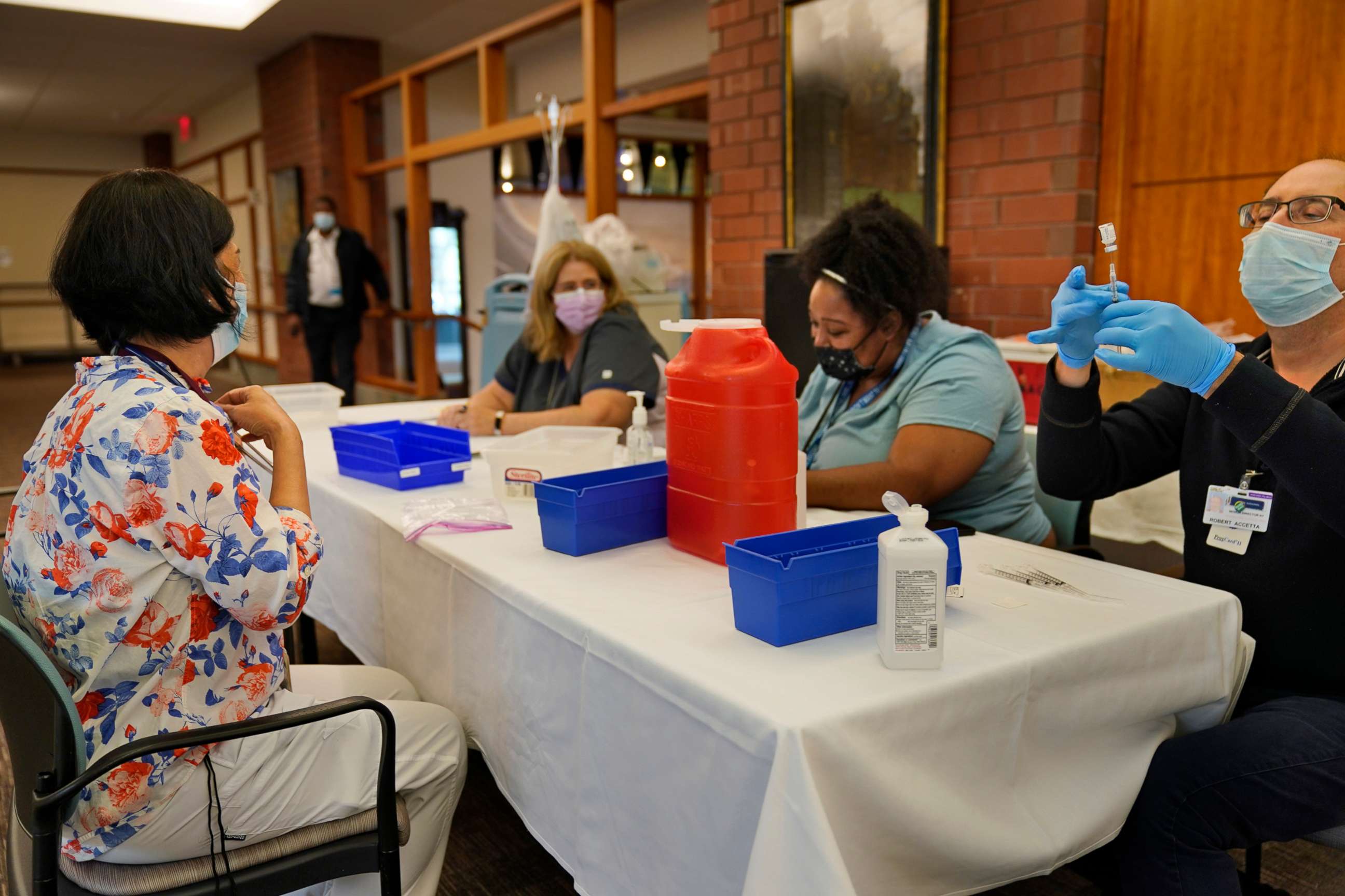 PHOTO: Cristina Licup, left, waits to receive her COVID-19 booster shot where she works at the Hebrew Home at Riverdale in New York, Sept. 27, 2021.