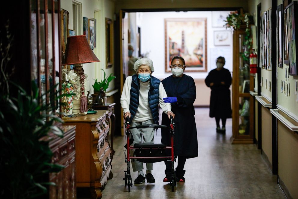 PHOTO: Resident Nancy Joh walks down the hall at Gordon Manor assisted-care facility in Redwood City, Calif., Jan. 28, 2021. Many in the area are frustrated by the slow pace of vaccination administration for nursing homes and assisted living facilities.