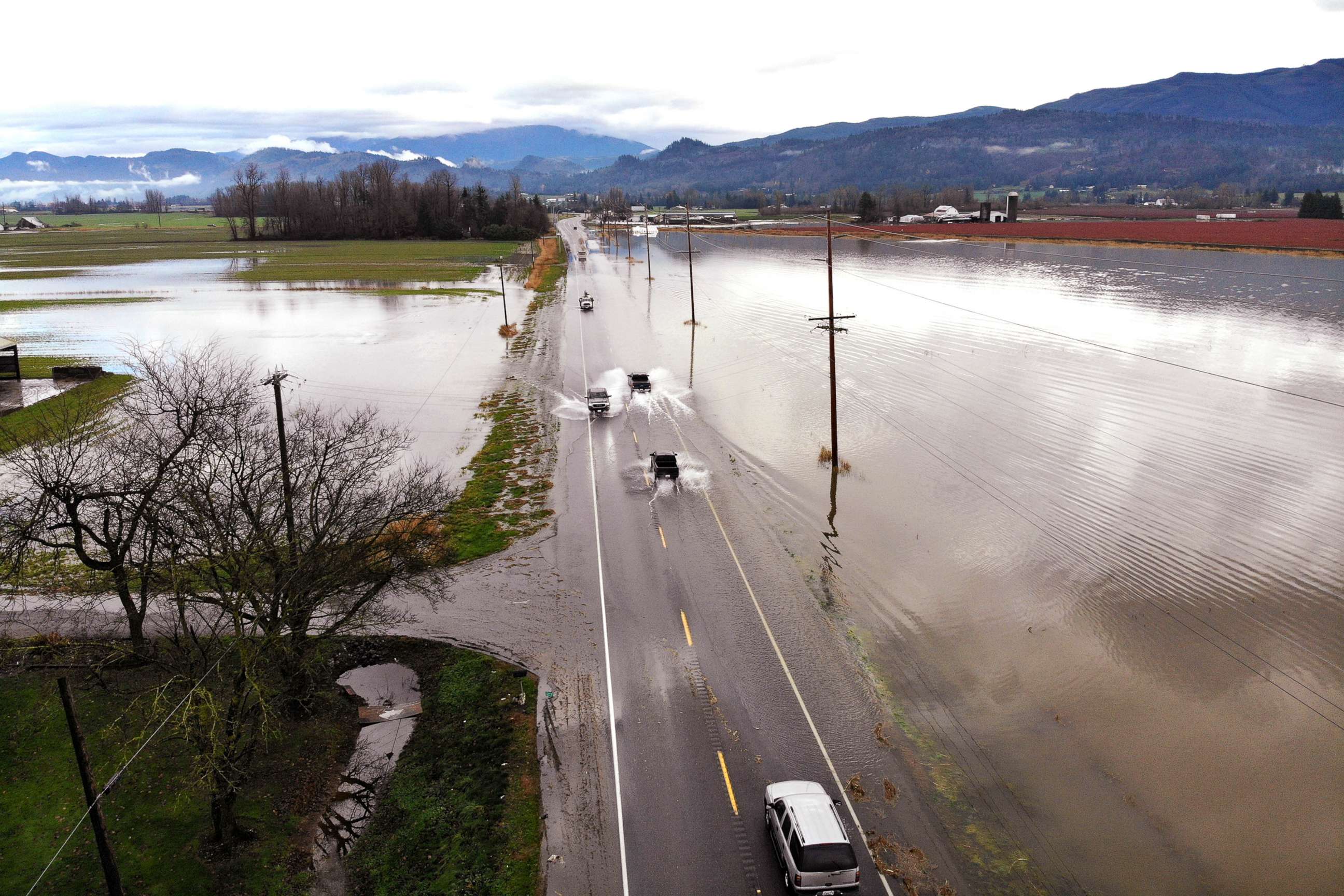 PHOTO: Vehicles navigate a flooded highway headed into Sumas, Wash., Nov. 29, 2021. 