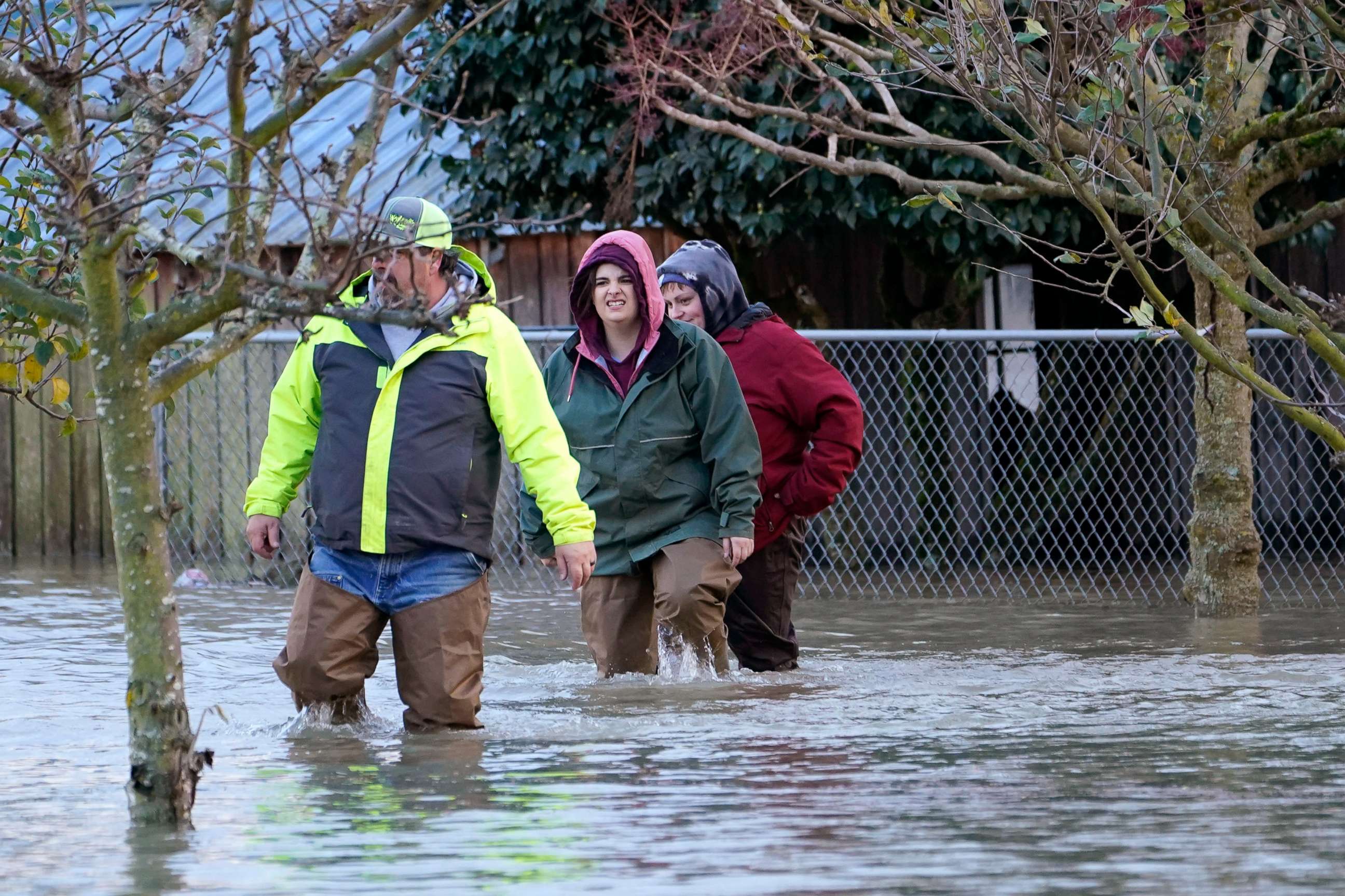 PHOTO: Dale Archer, left, leads his daughters Myranda and Krysten Archer through floodwater, Nov. 15, 2021, in Sedro-Woolley, Wash., after heavy rainfall brought major flooding of the Skagit River.