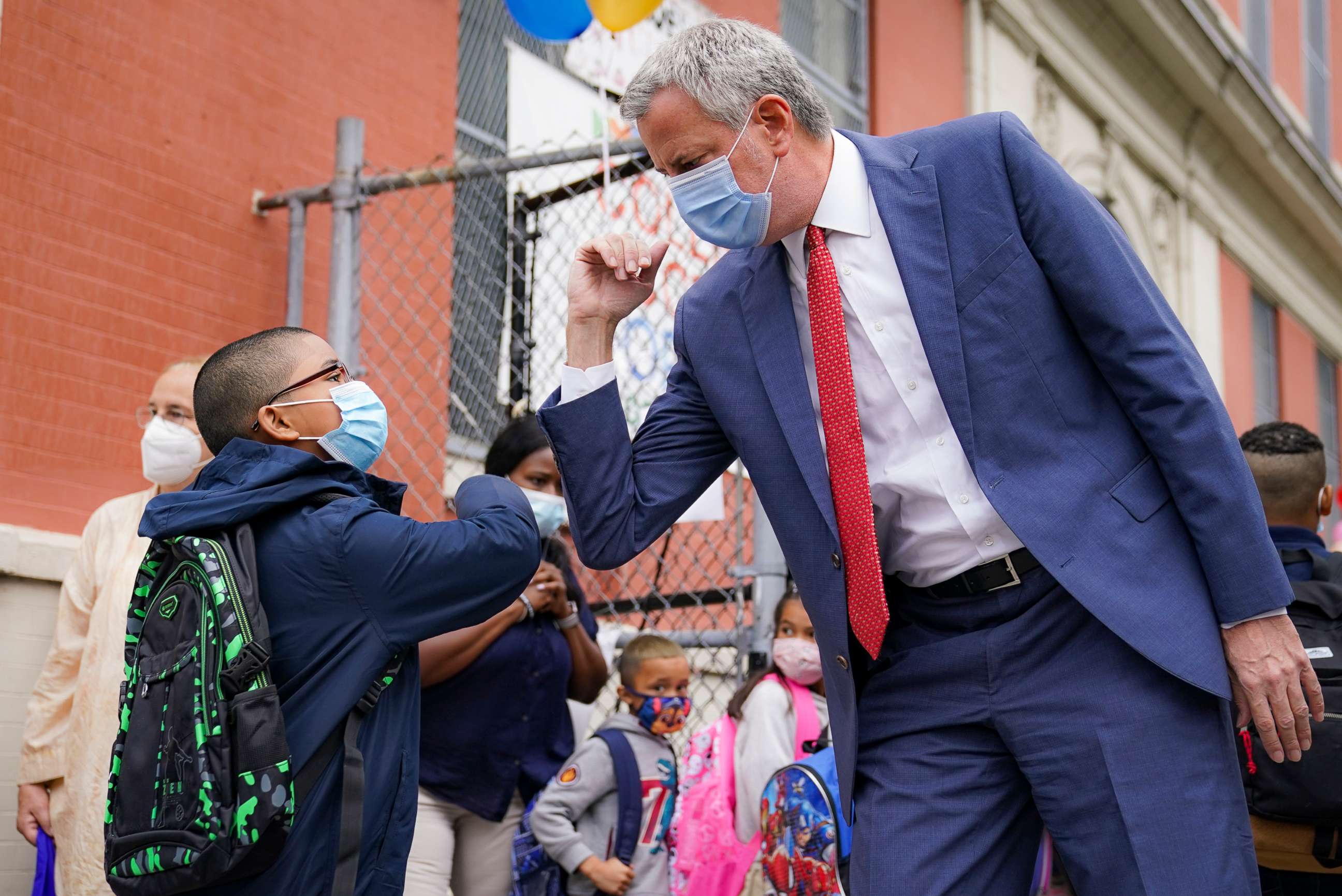 PHOTO: New York Mayor Bill de Blasio, right, greets students as they arrive for in-person classes outside Public School 188 The Island School, Sept. 29, 2020, in New York. 