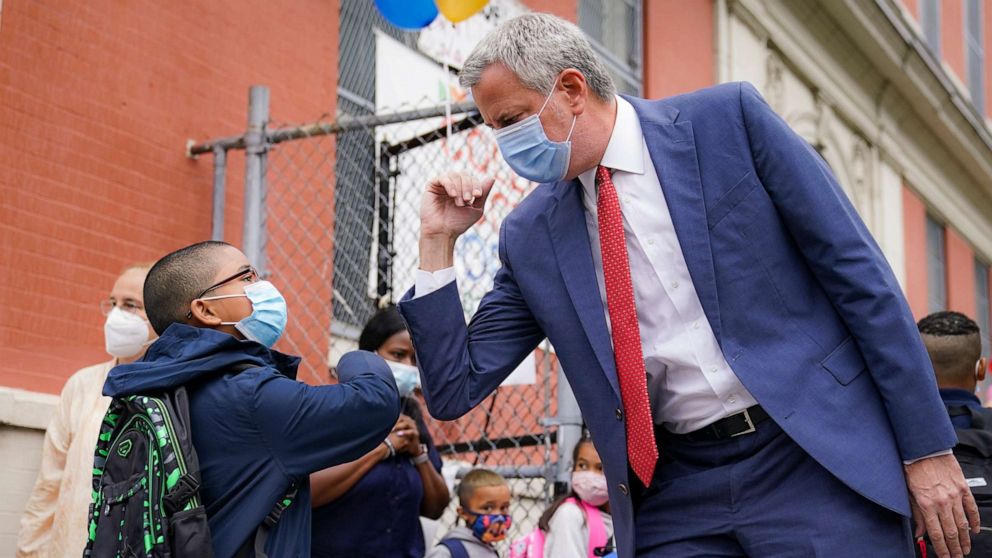 PHOTO: New York Mayor Bill de Blasio, right, greets students as they arrive for in-person classes outside Public School 188 The Island School, Sept. 29, 2020, in New York. 